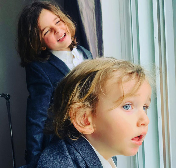 Two young boys looking out a window