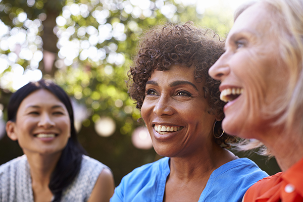 Mature Female Friends Socializing In Backyard Together