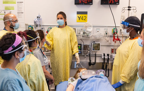 The team performs a debrief of the resuscitation, led by Dr. Nadia Primiani, the co-lead of the Schwartz / Reisman Emergency Centre in-situ Simulation Program. The debrief discusses what went well during the simulation session and what could be changed or improved in future simulations in preparation for pregnant adult/infant emergencies.