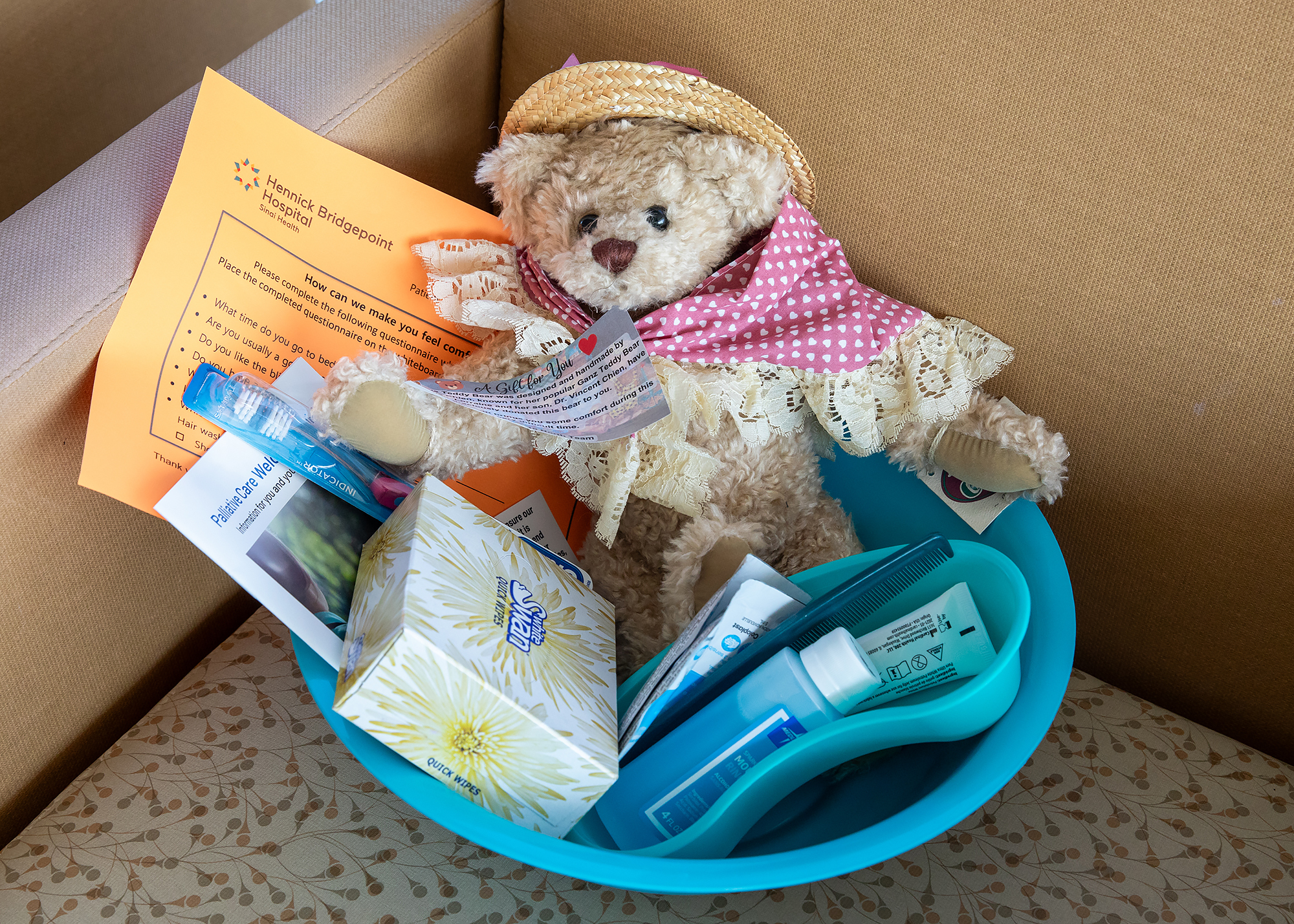 A personalized teddy bear is placed on a patient’s bed upon admission, as part of a welcome kit.