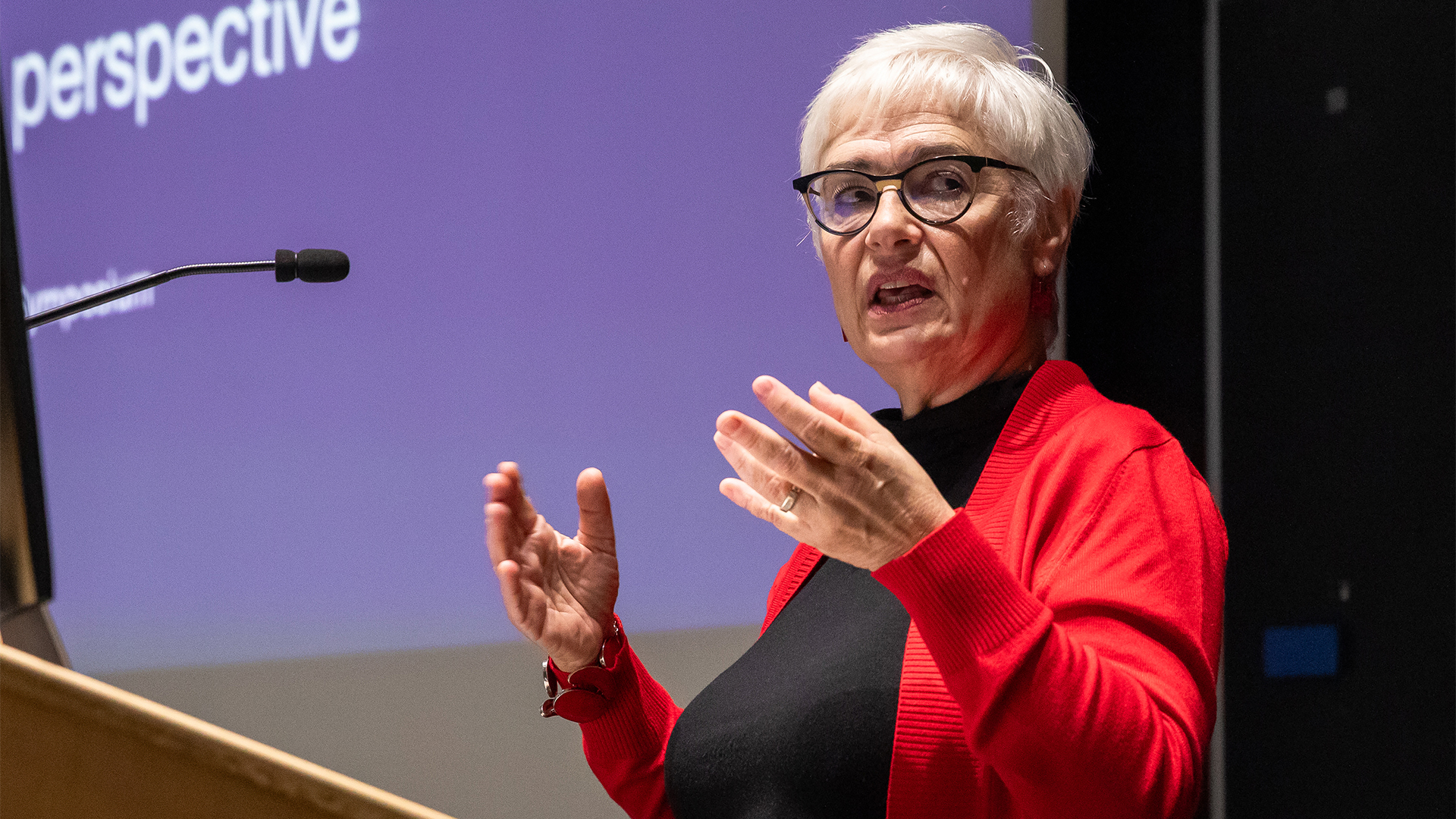 Brina Ludwig-Prout speaking at a podium in the Mount Sinai Hospital auditorium.