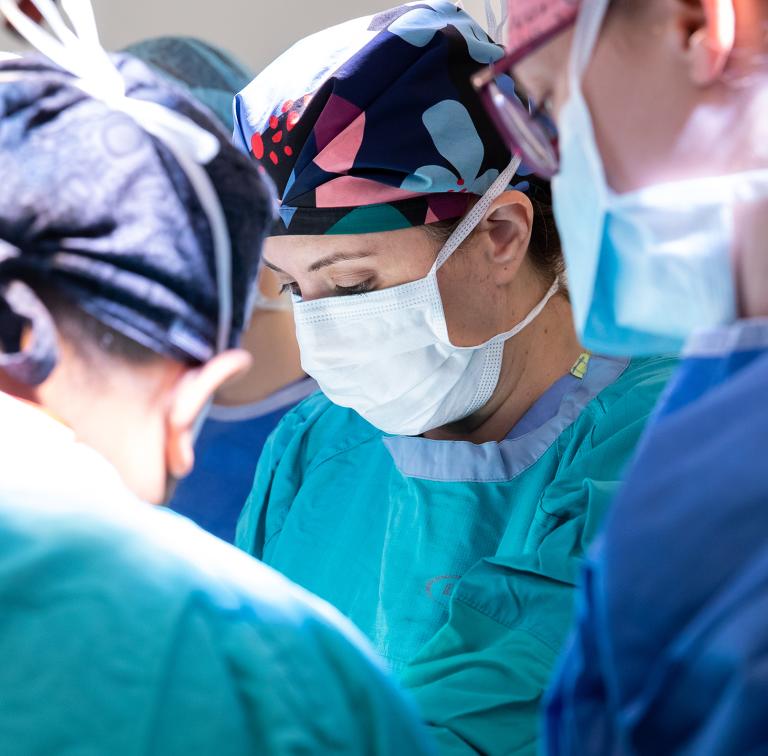 A surgeon and other operating room team members perform surgery