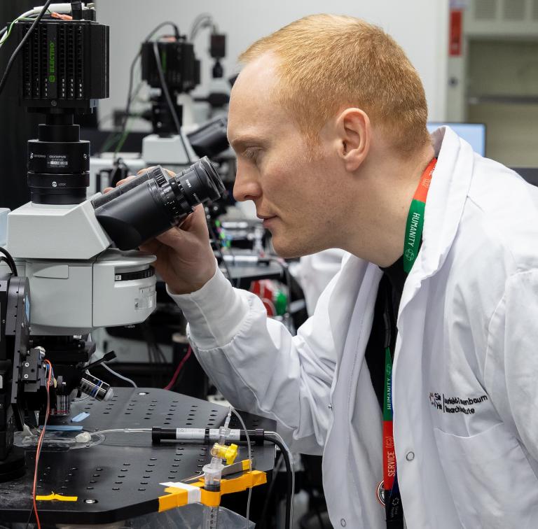 A LTRI researcher looks into a piece of research equipment.