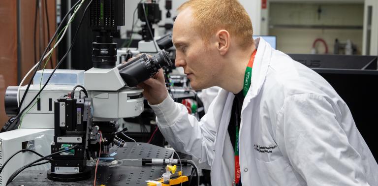 A LTRI researcher looks into a piece of research equipment.