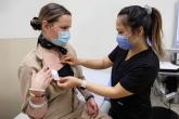 An oncology nurse assesses a bandage on a patient's chest