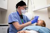 A dentist examines a female patient's teeth