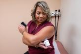 A patient holds her glucose monitor against the sensor on her arm