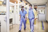 Two emergency medicine physicians walk down a hallway in the emergency department