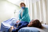 A physician examines a patient's abdomen