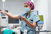 An anesthesiologist prepares an IV tube