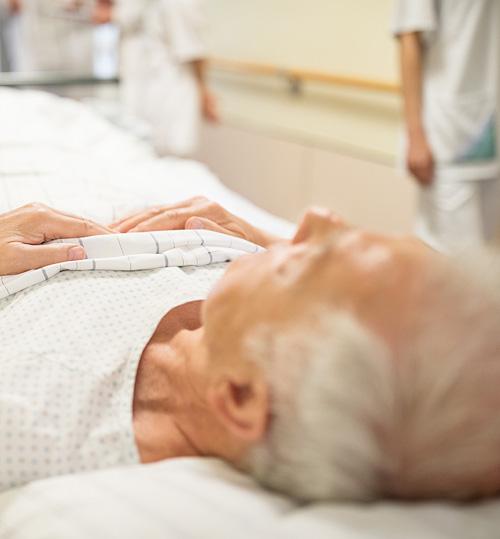 A senior man lying in a hospital bed