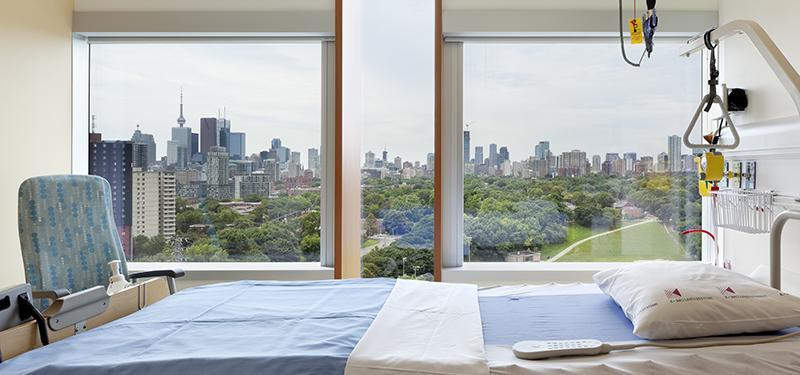 A panoramic view of the city skyline through large windows of hospital room