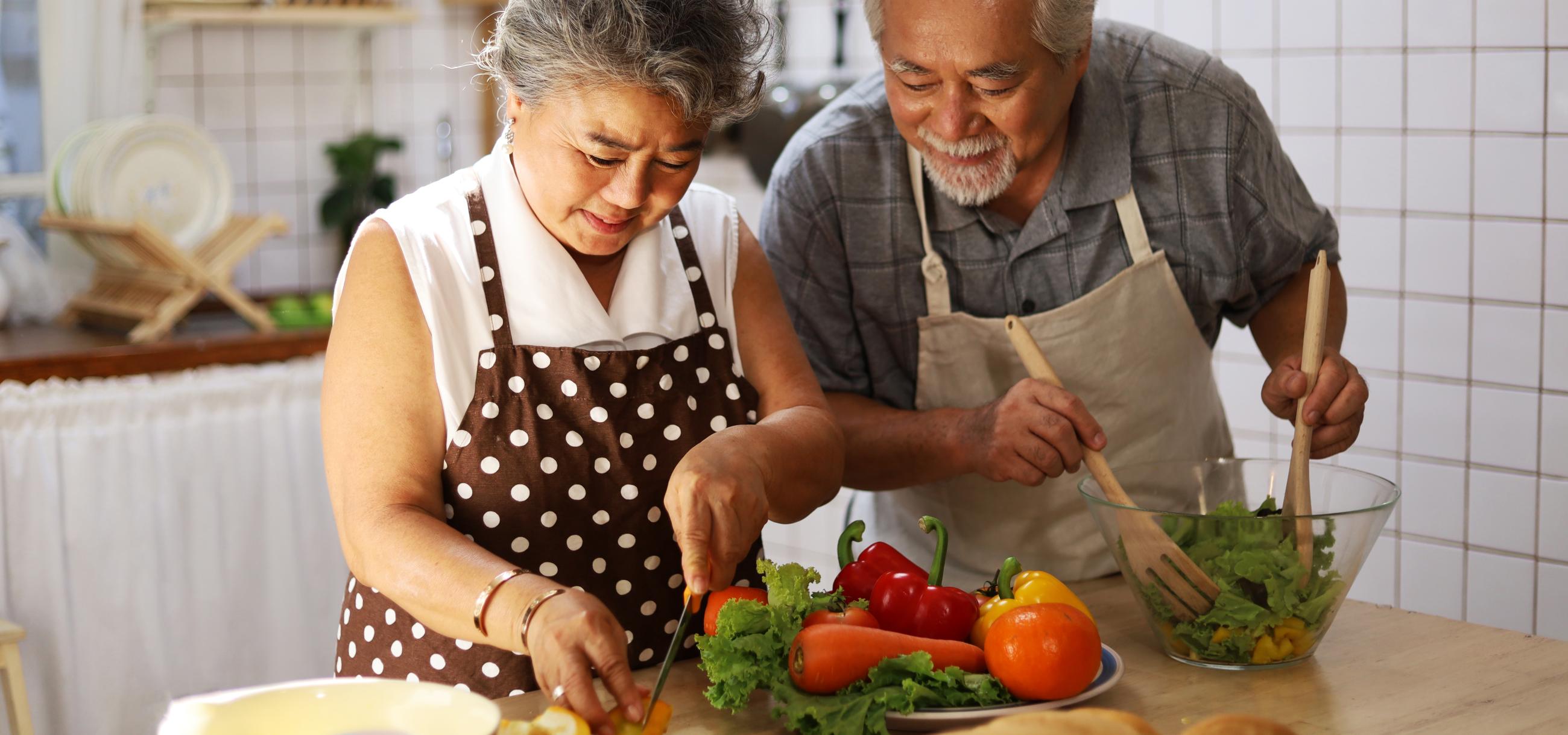 couple making salad in kitchen