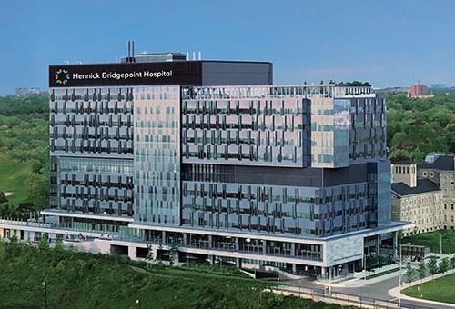 Long shot of modern looking hospital building with Hennick Bridgepoint Hospital sign.