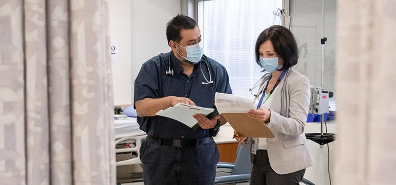 Two healthcare workers standing and reviewing documents