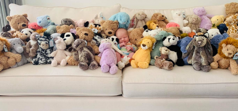 Baby Bodhi, surrounded by stuffed animals