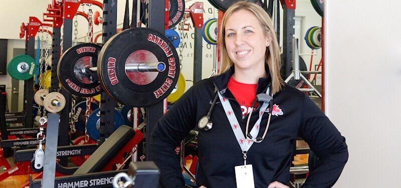 Dr. Kim Coros in front of athletic weight racks