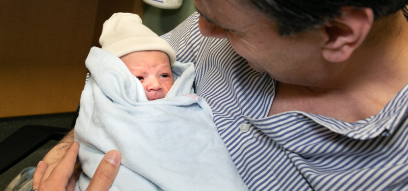 Father holding preterm baby in the neonatal intensive care unit