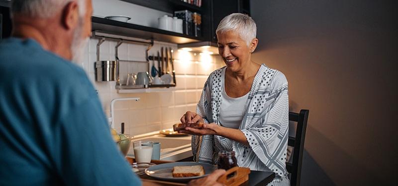 Two people prepare a meal together at a kitchen counter. 