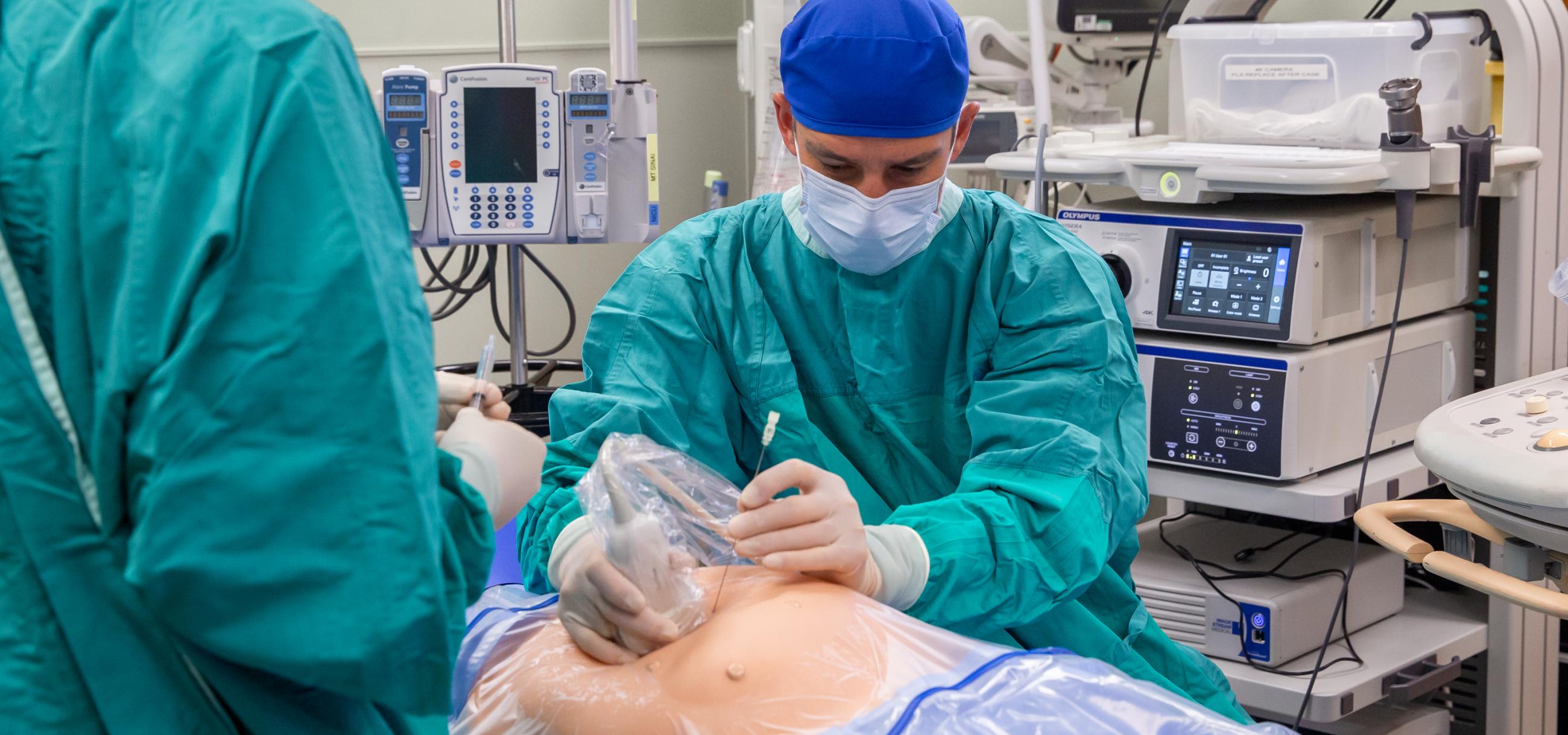 A physician demonstrates the use of fetal ultrasound for a procedure. 