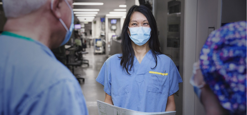 Dr. Christie Lee speaks with colleagues in the ICU.