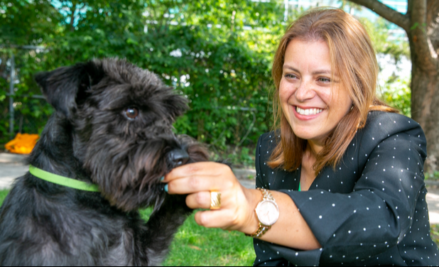 Dr. Caroline Kramer with her black miniature Schnauzer in the park. 