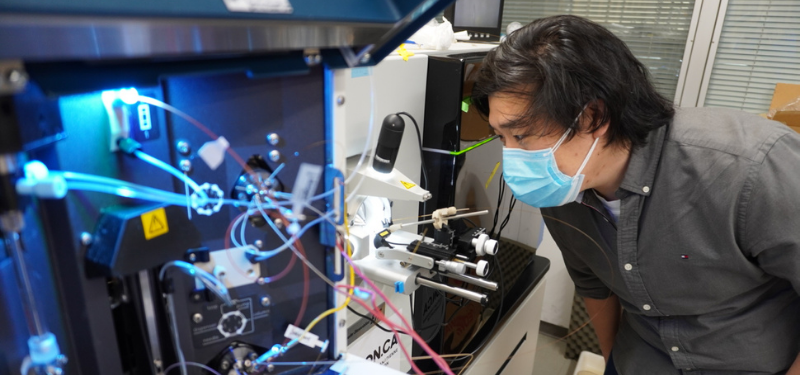 researcher examining a specimen through a microscope