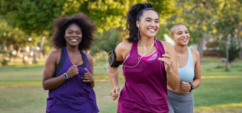 Three women running together outside.