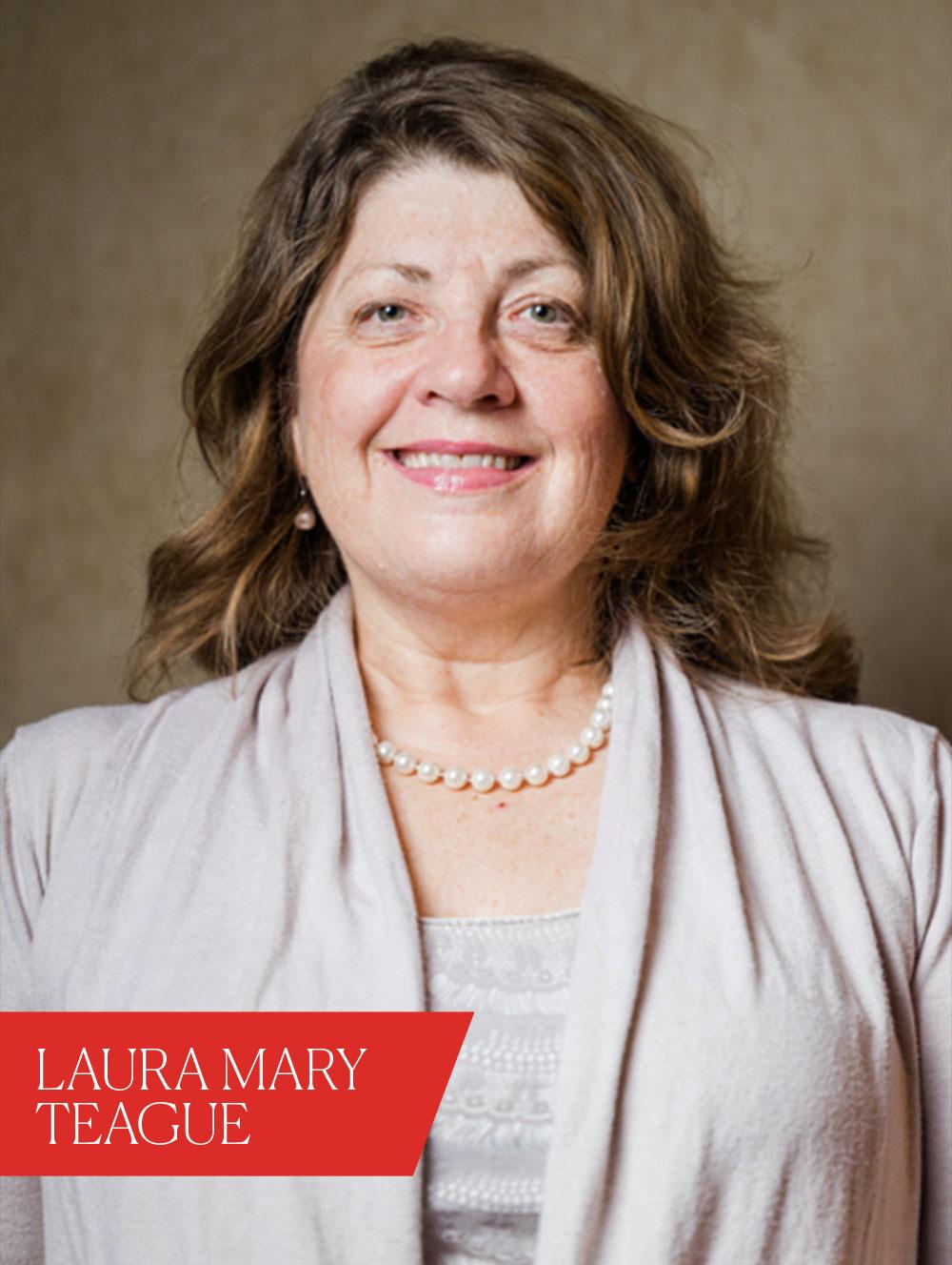 Woman smiling. There is a red banner that says, 'Laura Mary Teague'