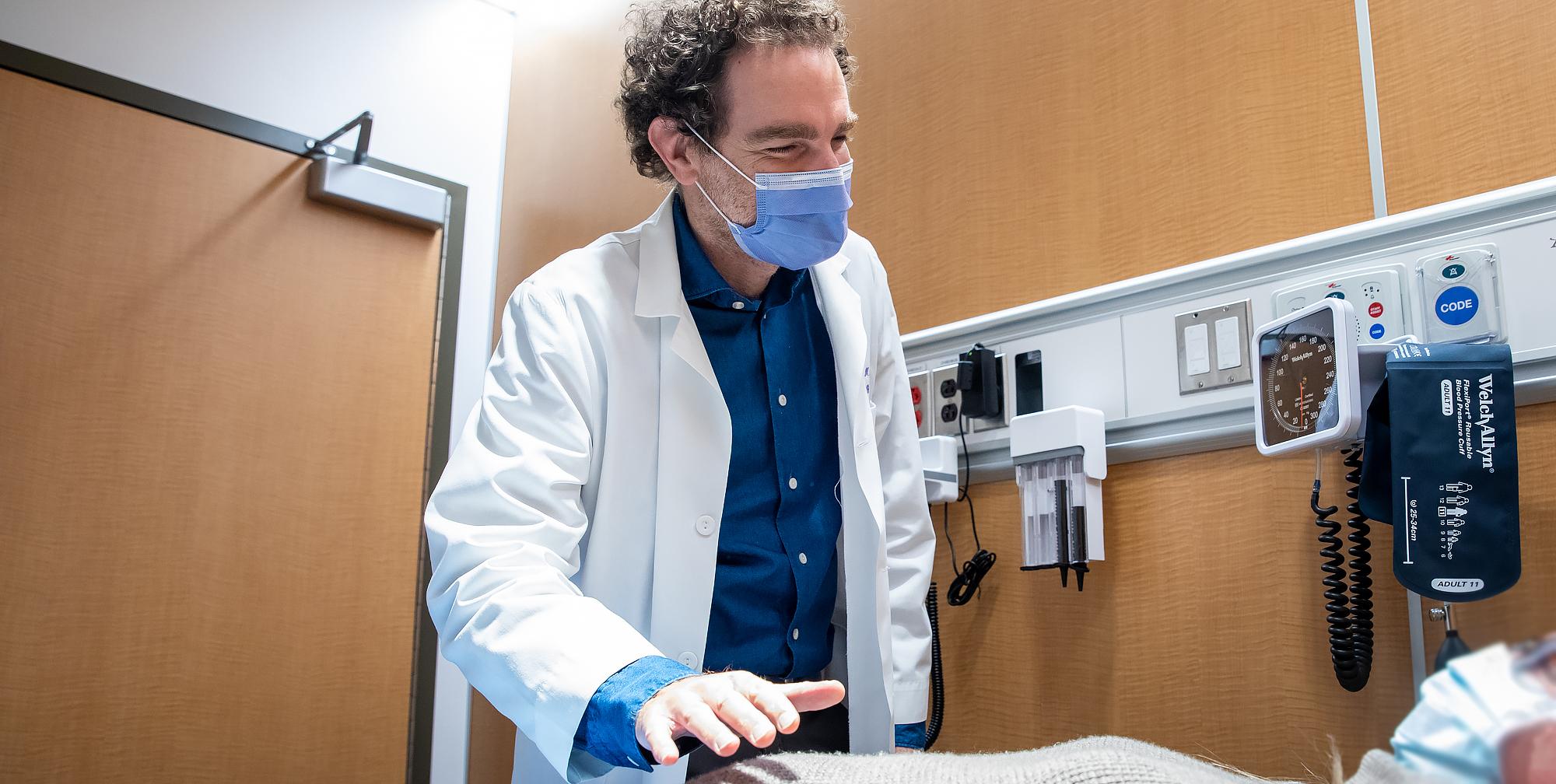 Picture of Dr. Adam Weizman who is examining a patient.