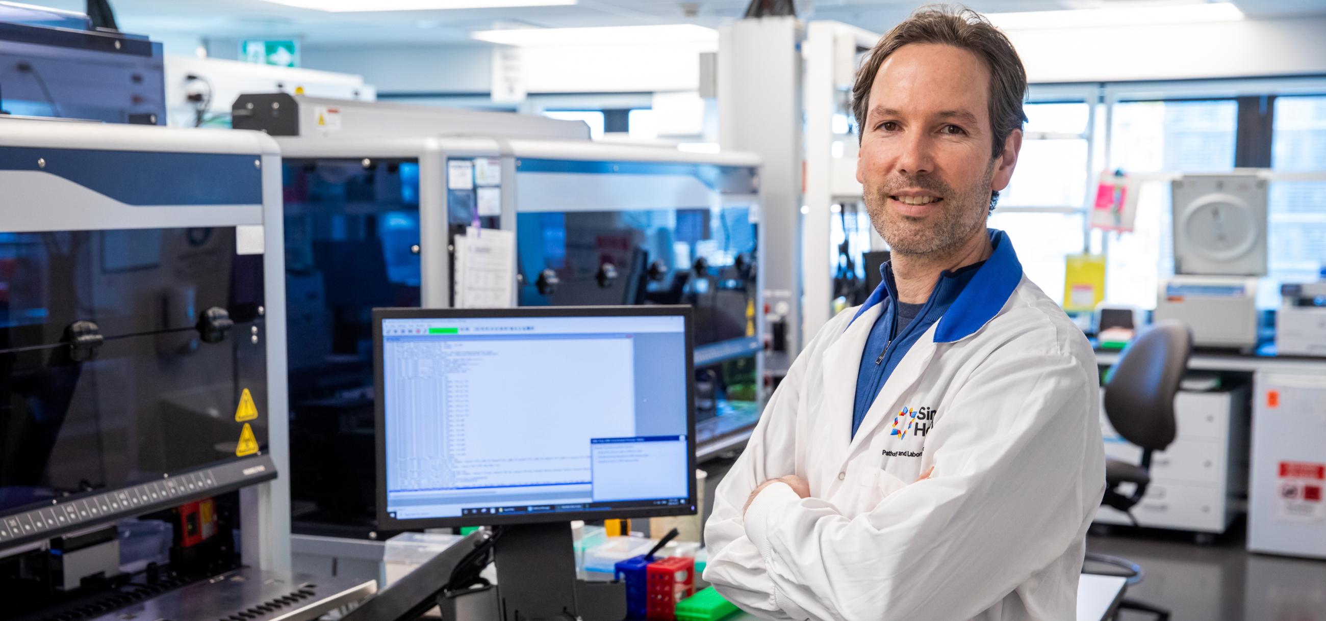 A photo of Sinai Health’s Dr. Jordan Lerner-Ellis in the lab with this arms crossed. 