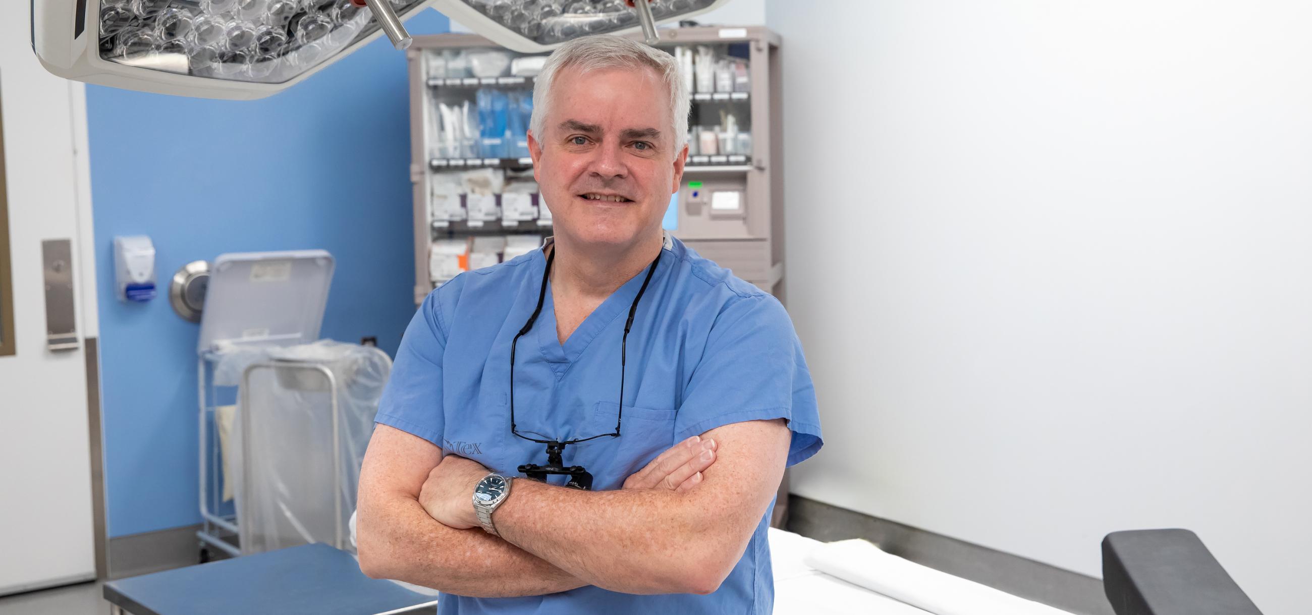 A photo of Dr. Ian Witterick, Sinai Health's surgeon-in-chief in a medical setting with this arms crossed 