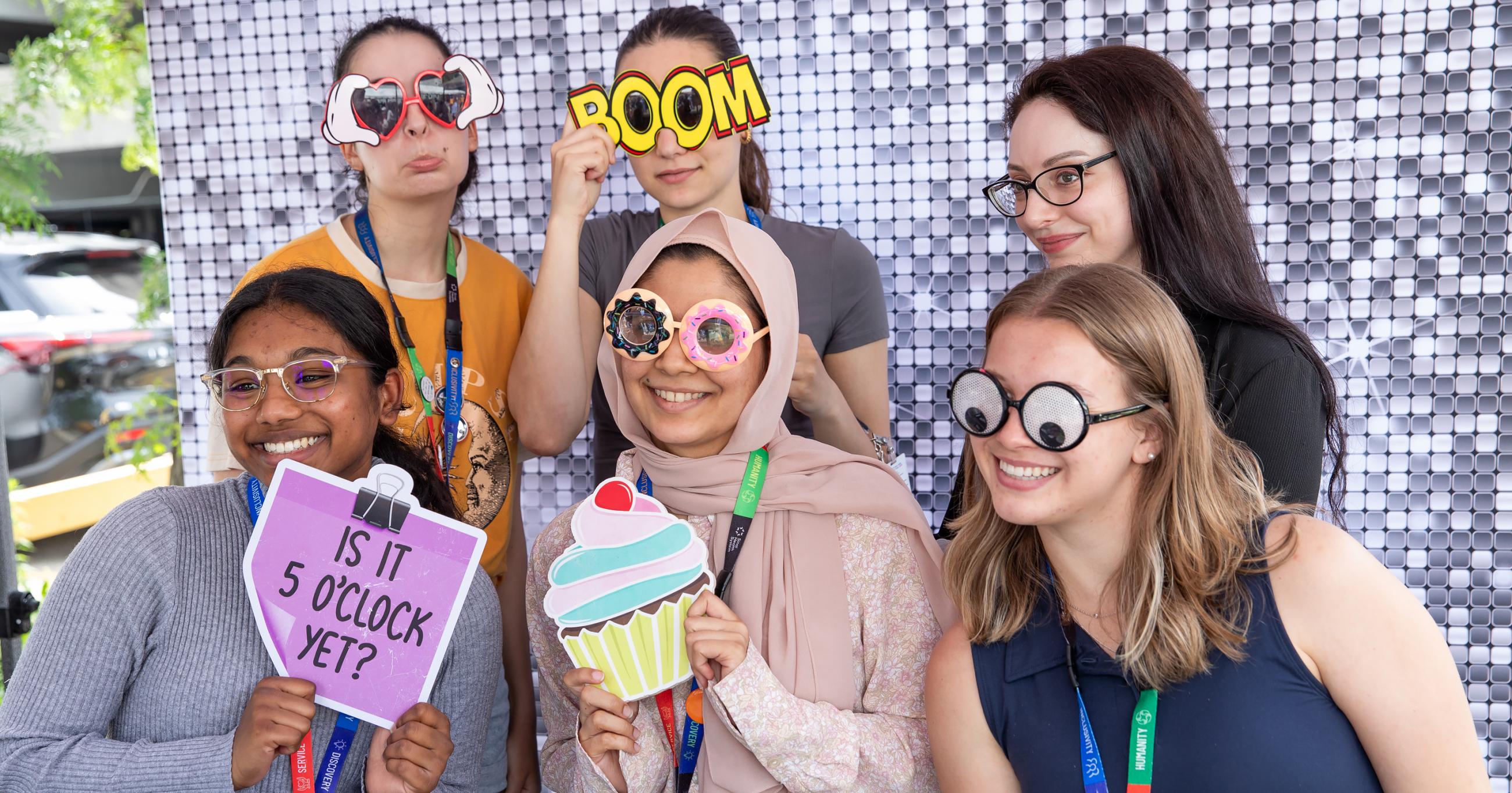 Group of people posing with props in a photobooth