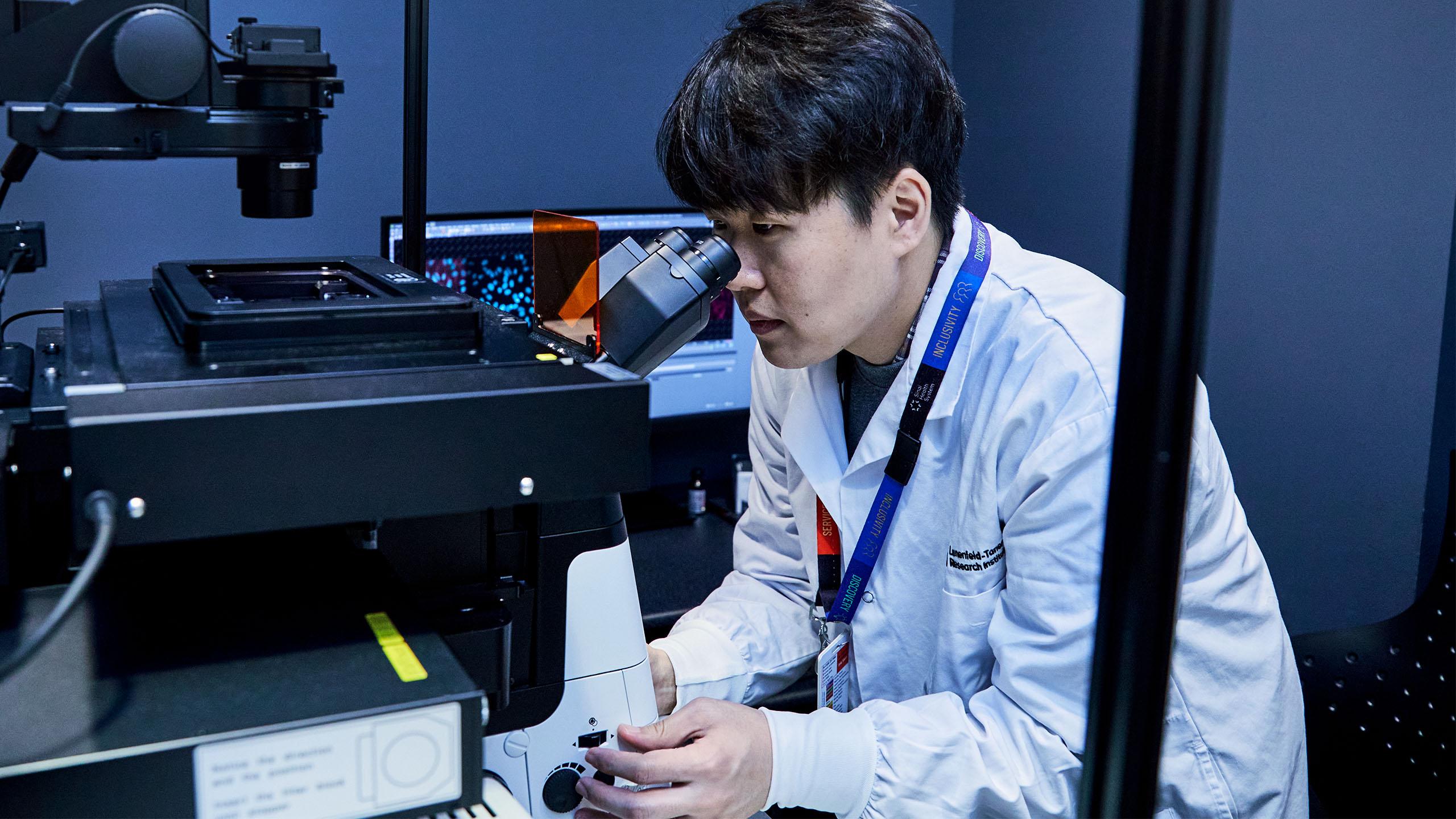 Researcher looking through a computerized microscope