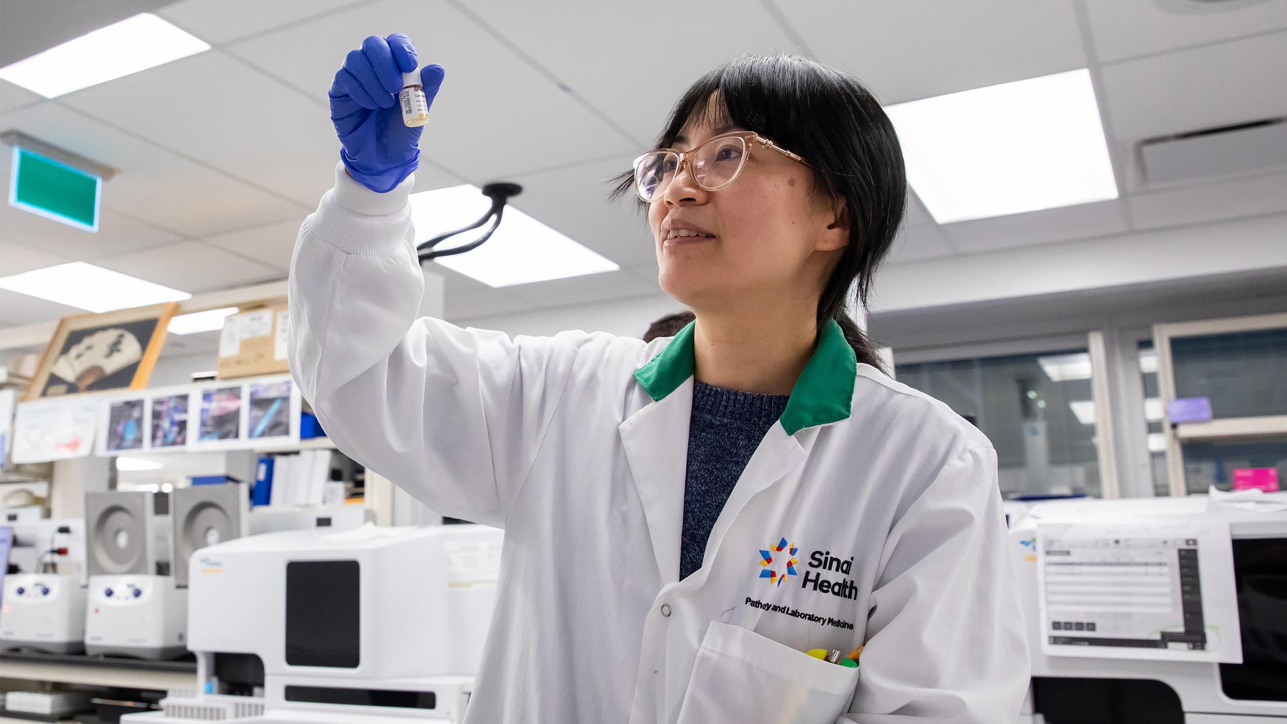 Female lab researcher looking at test tube