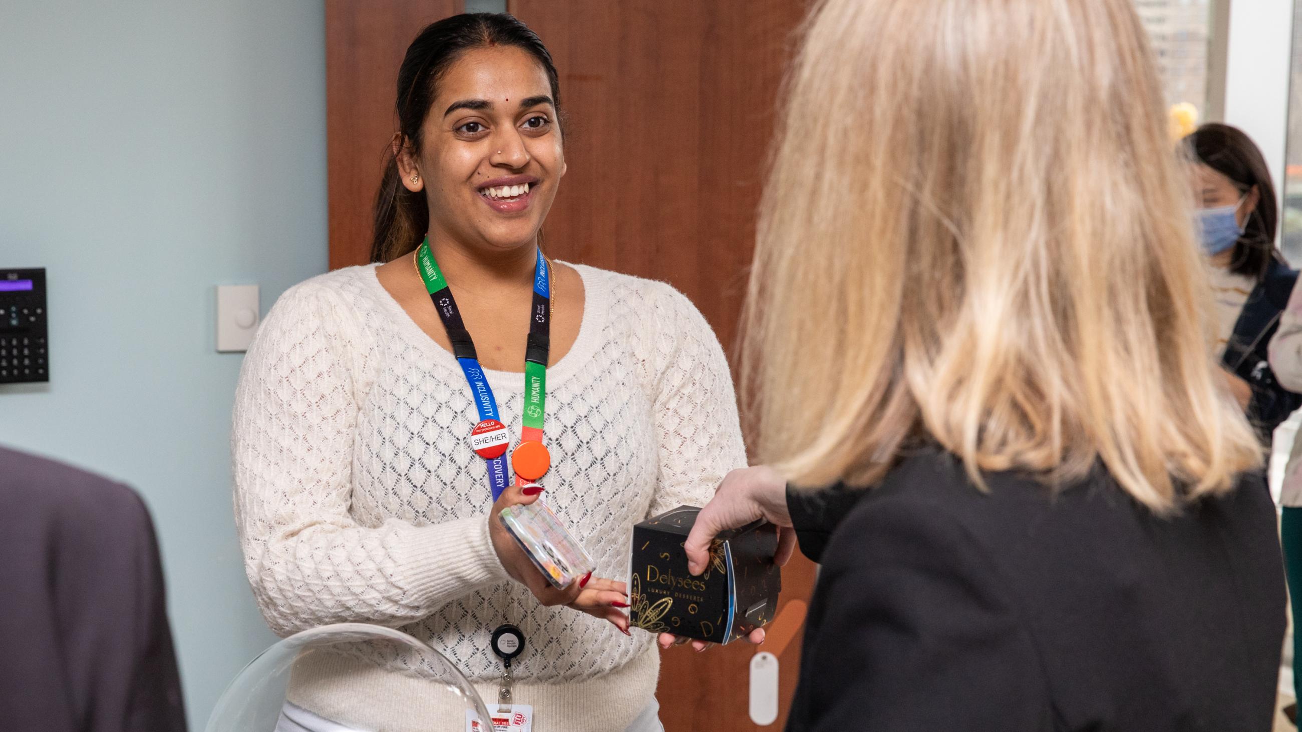 A staff member receives a holiday treat at Sinai Health’s Holiday Open House.