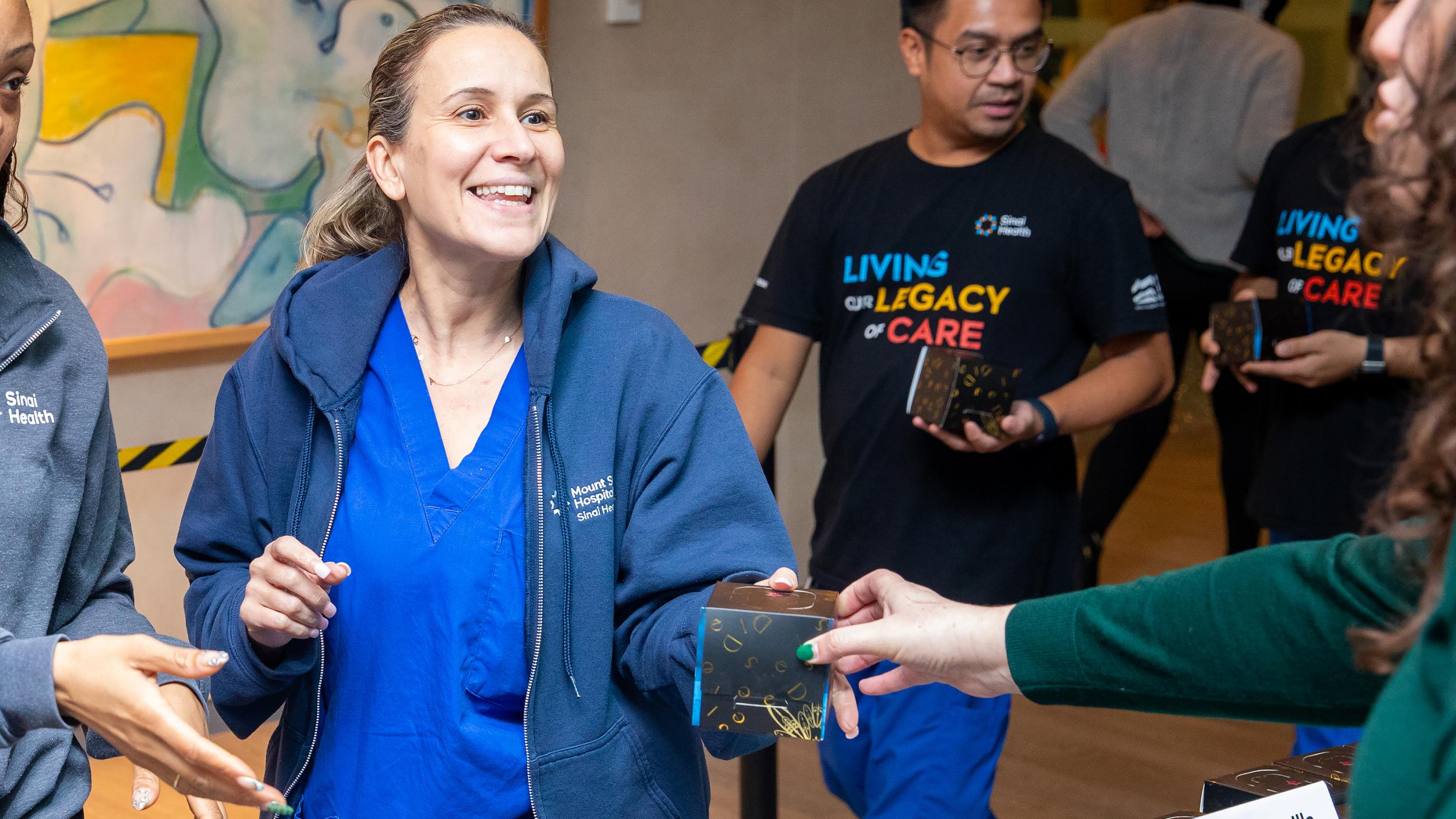 A staff member receives a holiday treat at Sinai Health’s Holiday Open House.