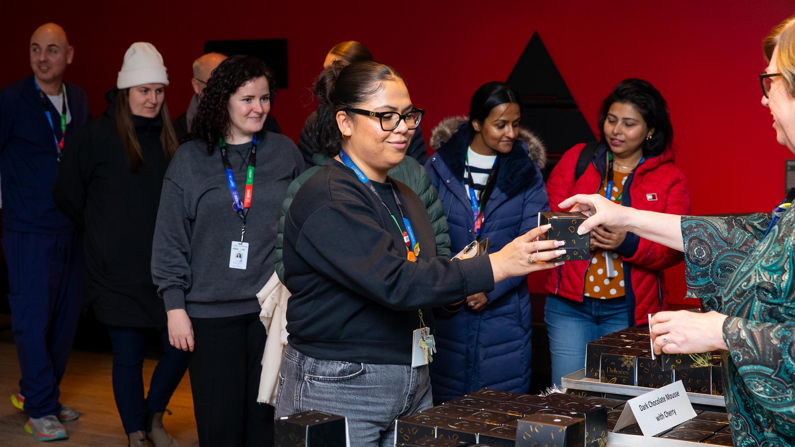 Staff members receive a holiday treat at Sinai Health’s Holiday Open House.