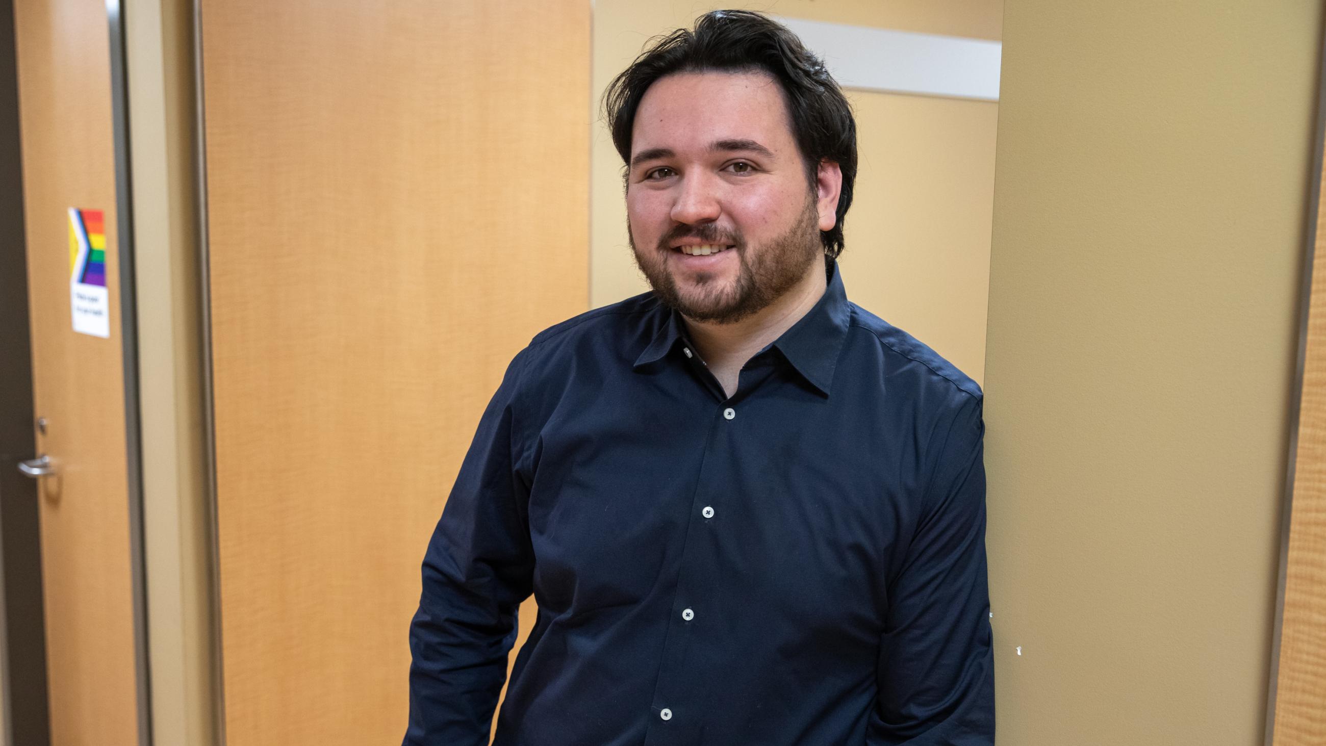 An Administrative Coordinator poses for his headshot in the hallway of Sinai Health’s Women & Infants’ Health Department.