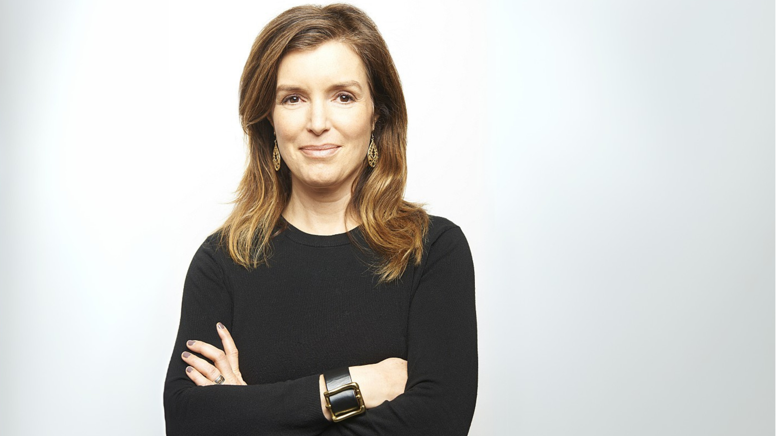 woman wearing black shirt stands with crossed arms