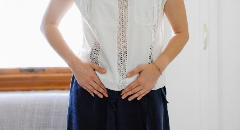 woman holds her abdomen
