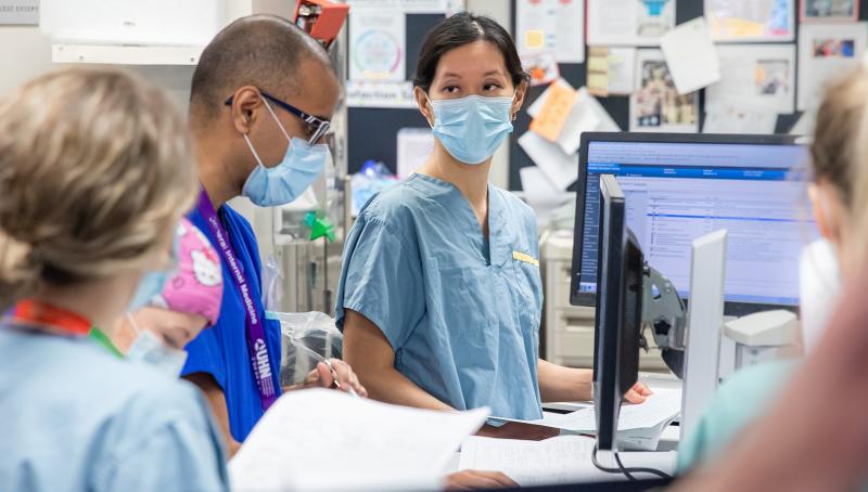 Dr. Christie Lee meets with team members in the ICU.