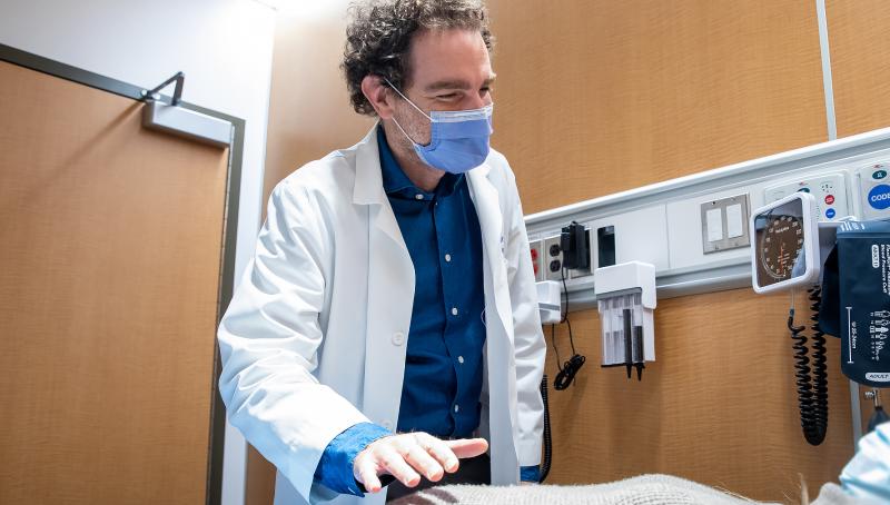 Picture of Dr. Adam Weizman who is examining a patient.