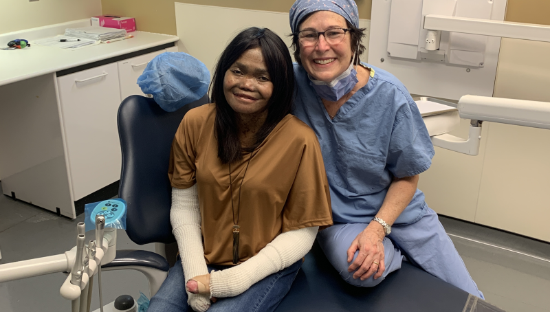 doctor and patient sit together on dentist chair