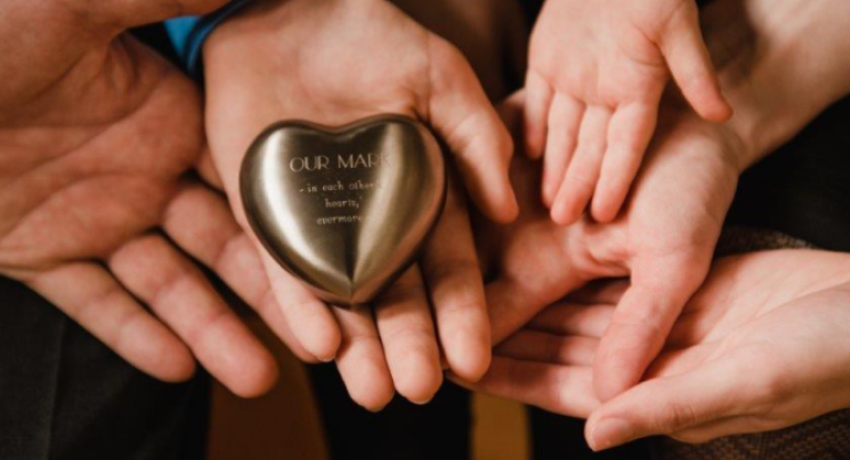 Photo of Mark’s family holding on to a precious memento provided by Lindsay Coad