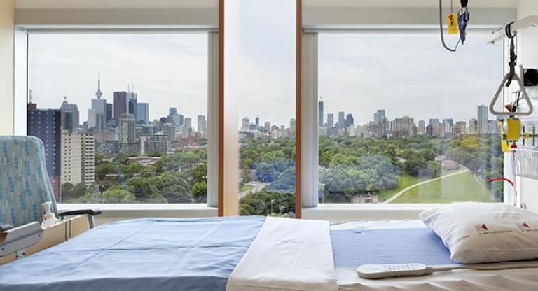 A panoramic view of the city skyline through large windows of hospital room