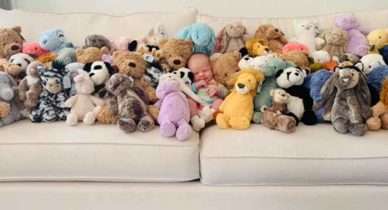 Baby Bodhi, surrounded by stuffed animals