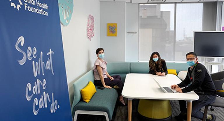 Three Sinai Health Foundation staff members work in their office 