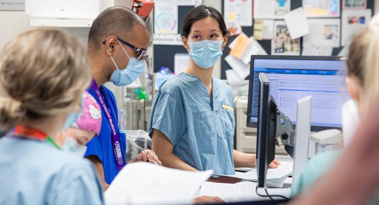 Dr. Christie Lee meets with team members in the ICU.