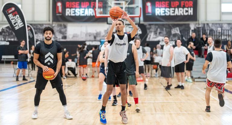 Man shooting a basketball surrounded by other players